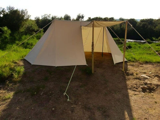 Beige tent set up in a natural outdoor setting with trees and grass.