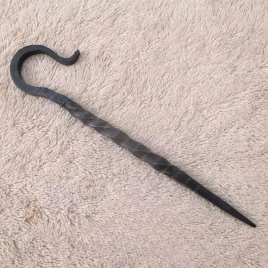 Black metal walking cane with curved handle on a beige carpet