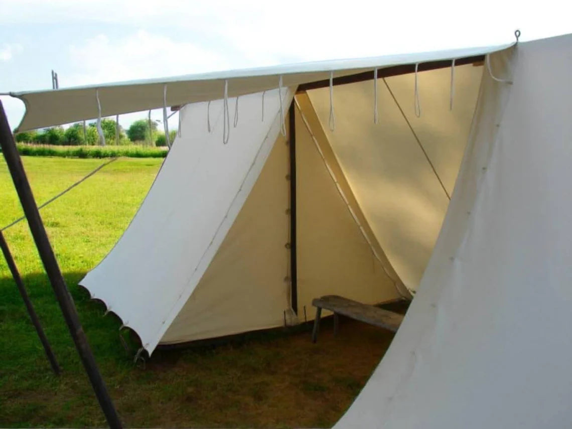 White tent with a bench inside, set up outdoors on grass.
