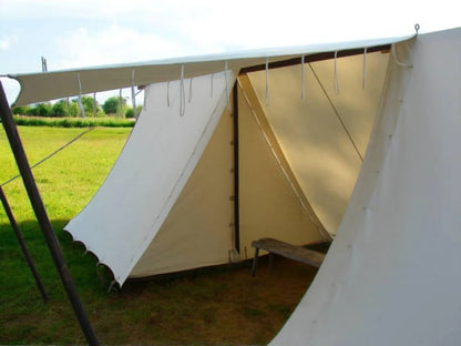 White tent with a bench inside, set up outdoors on grass.