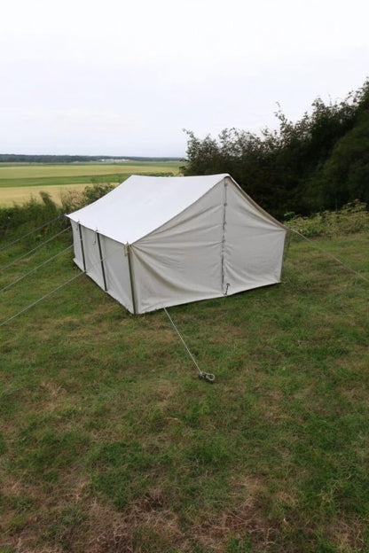 White tent set up on a grassy field with a scenic background