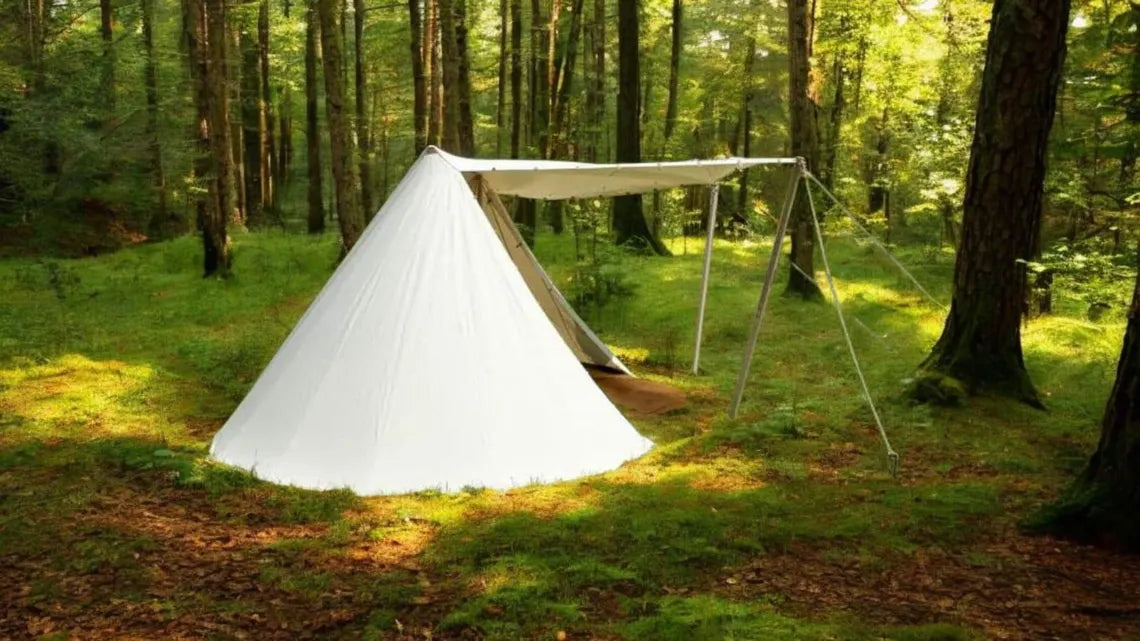 White tent set up in a forest clearing