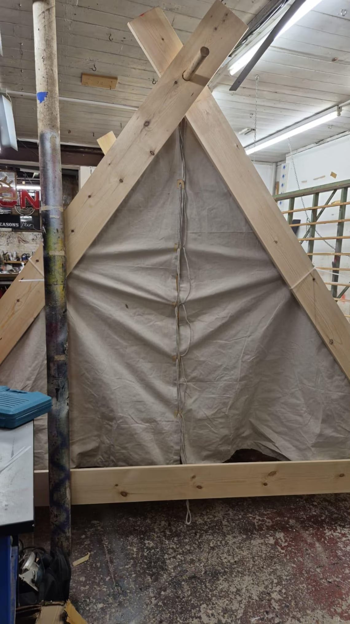 Wooden frame with tarp in a workshop setting