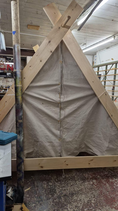 Wooden frame with tarp in a workshop setting