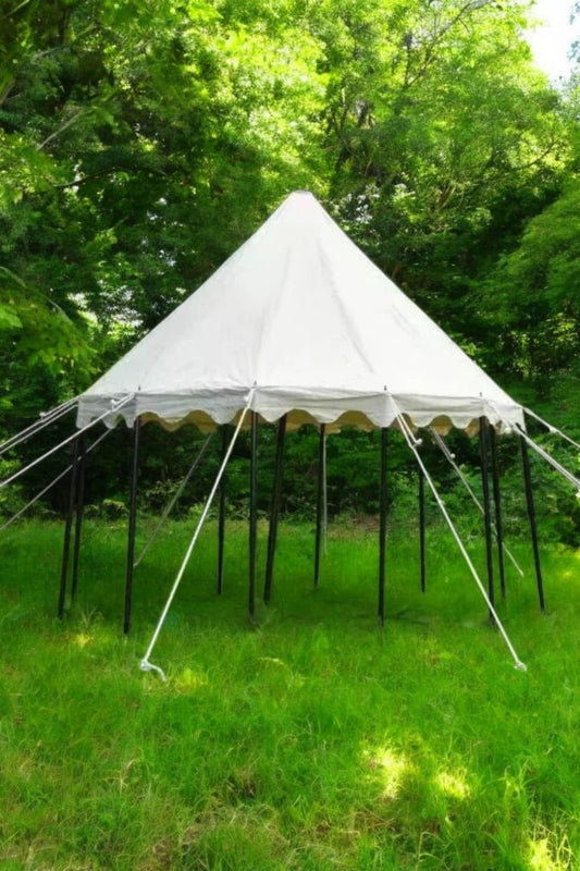 White tent with black legs on a grassy area with trees in the background