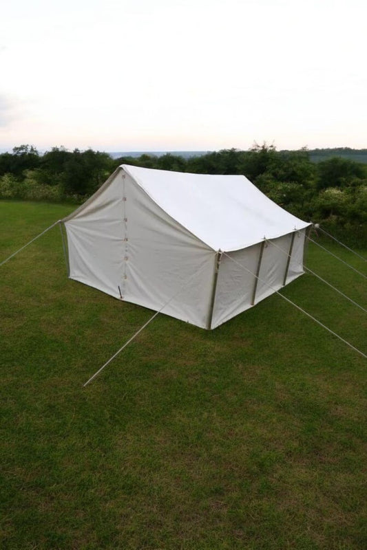 White tent on grass with trees in the background