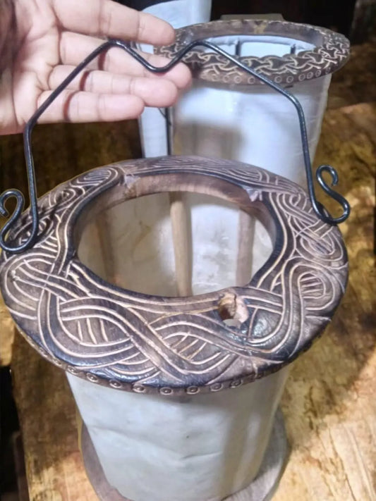 Decorative metal holder with intricate designs on a white candle