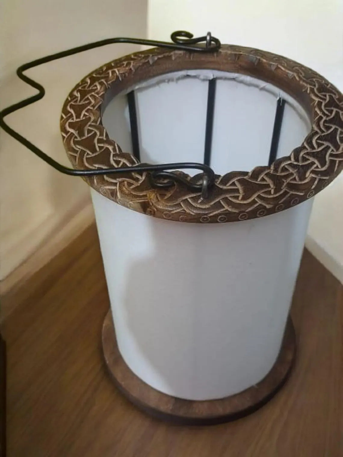 Decorative lamp with intricate metalwork on a wooden surface