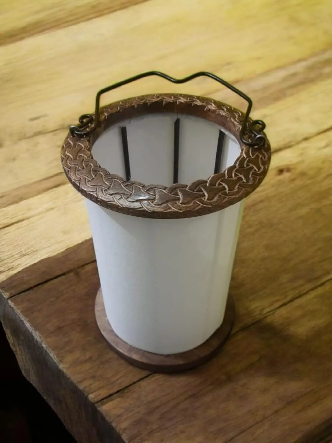 White cylindrical container with a decorative brown rim on a wooden surface