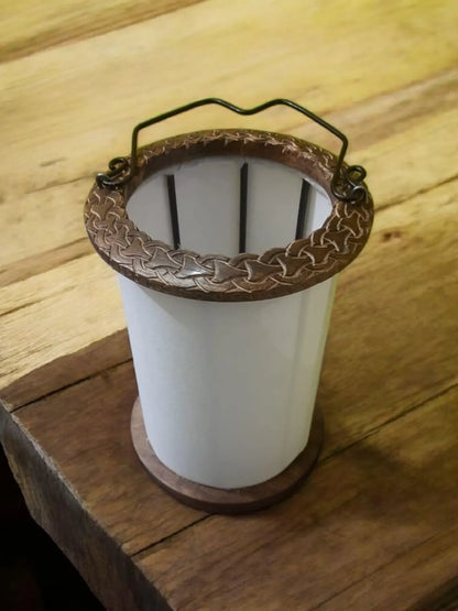 White cylindrical container with a decorative brown rim on a wooden surface