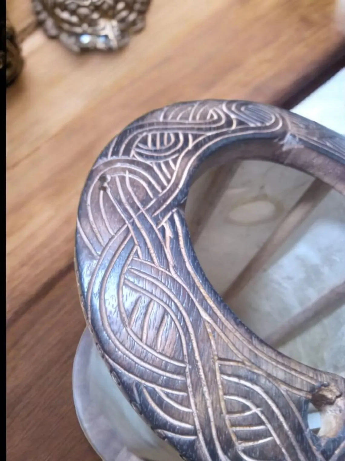 Decorative metal object with intricate patterns on a wooden surface