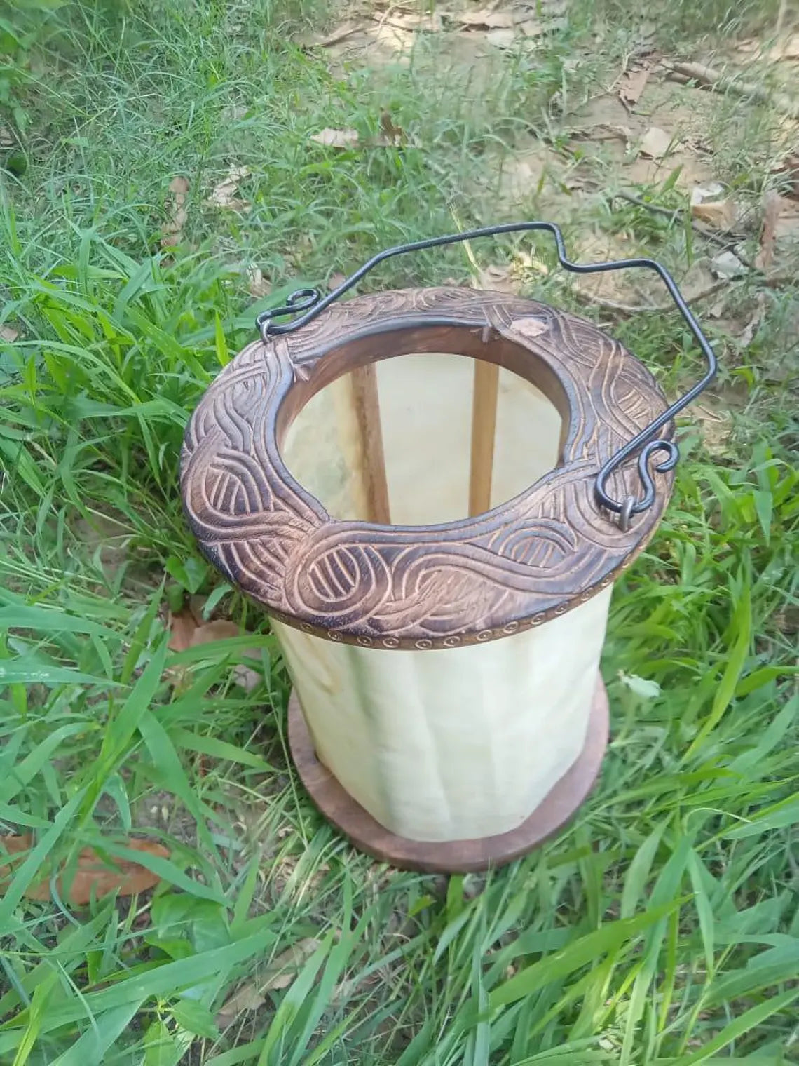 Decorative spool of thread with intricate design on grass