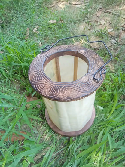 Decorative spool of thread with intricate design on grass