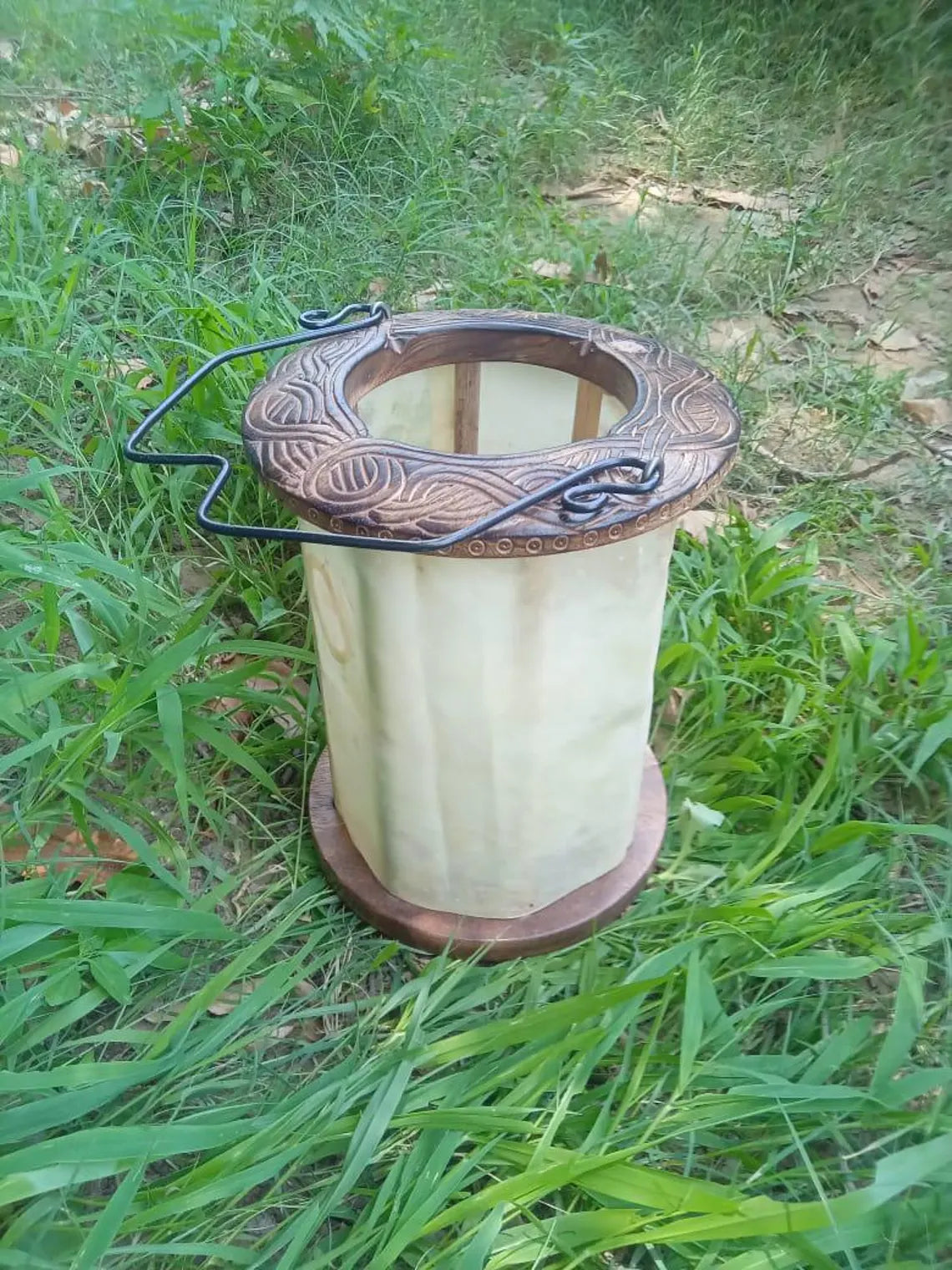 Candle holder with decorative top on grass