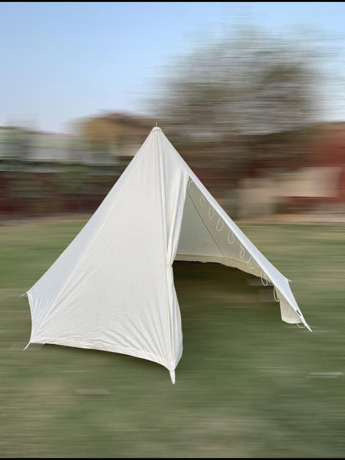 White tent on a grassy field with a blurred background