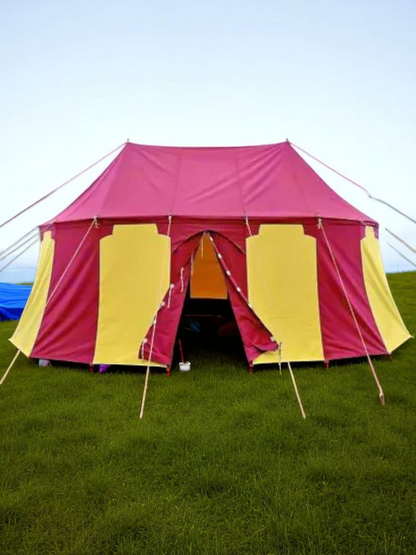 Red and yellow tent on grass with blue sky in the background