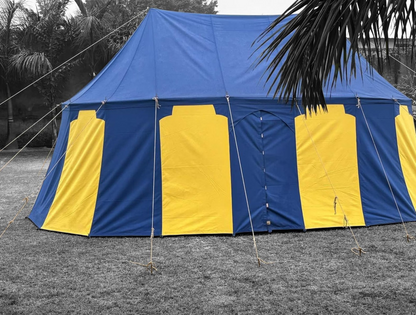Blue and yellow tent set up outdoors with trees in the background