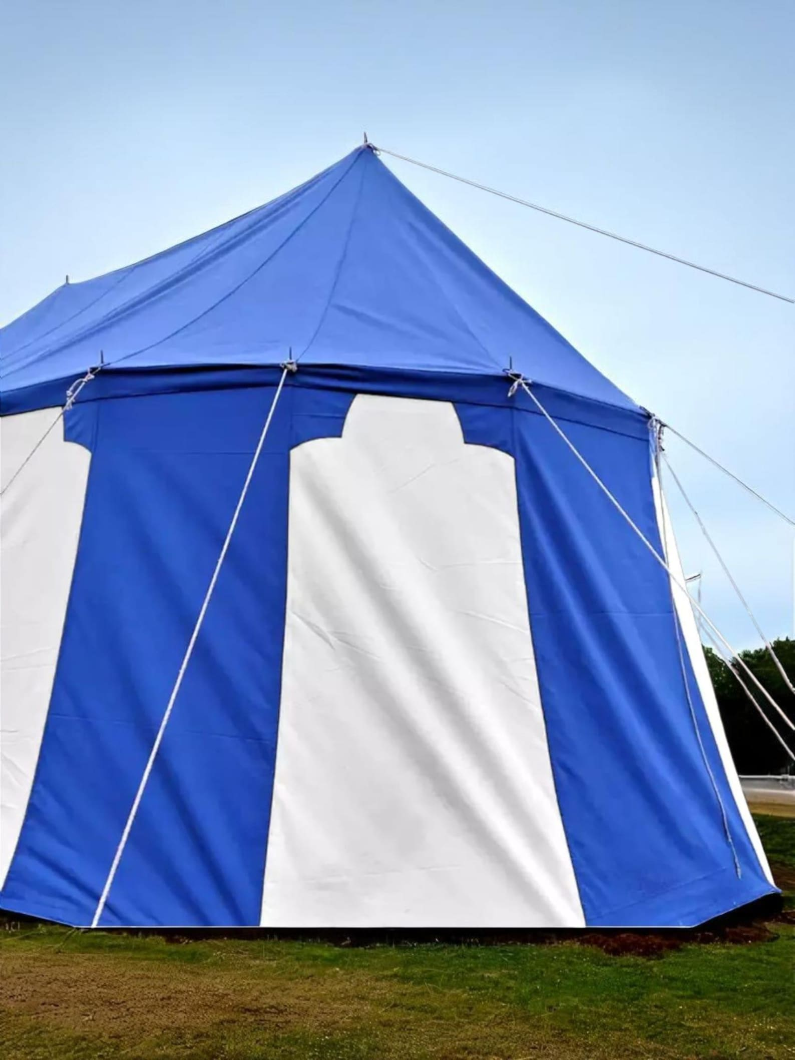 Blue and white tent set up outdoors with a clear sky background