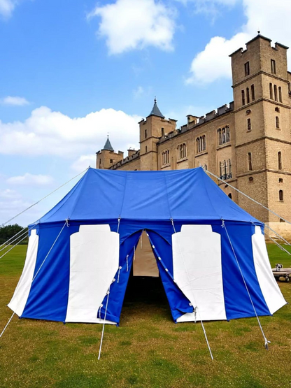 Blue and white tent set up outdoors with a castle in the background