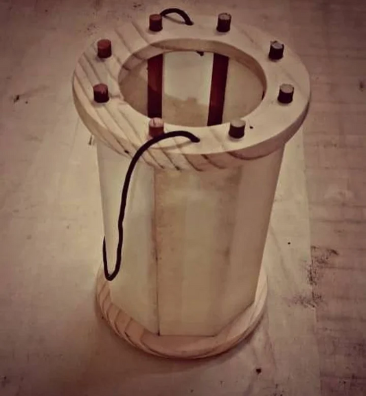 Wooden cylindrical device with electrical components on a concrete floor