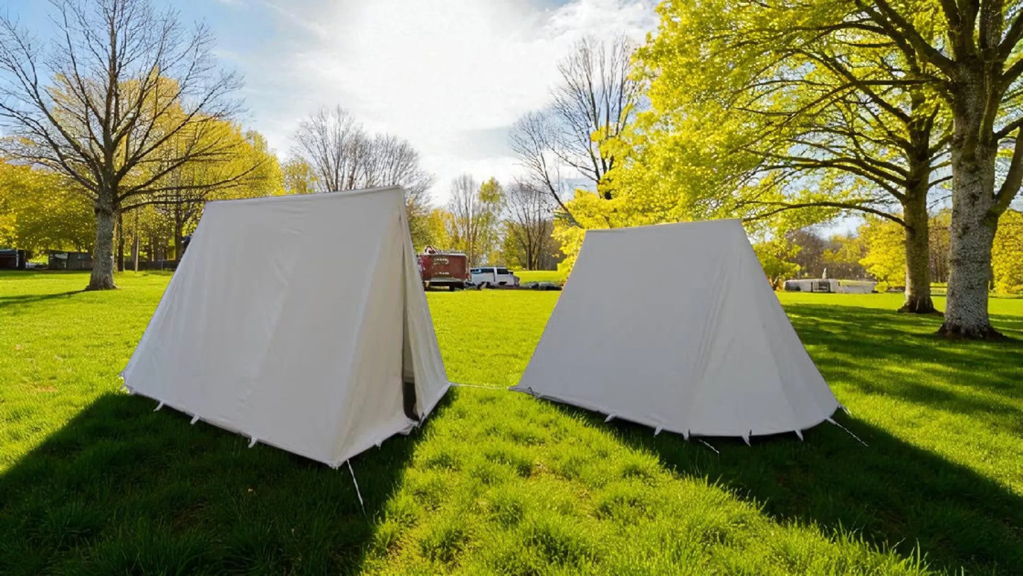 Two white tents on grass with trees and a clear sky in the background